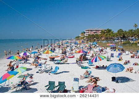 Touristes sur la plage pour les vacances d'été et dans l'eau