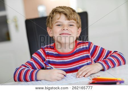 Happy Smiling Little Kid Boy At Home Making Homework At The Morning Before The School Starts. Little