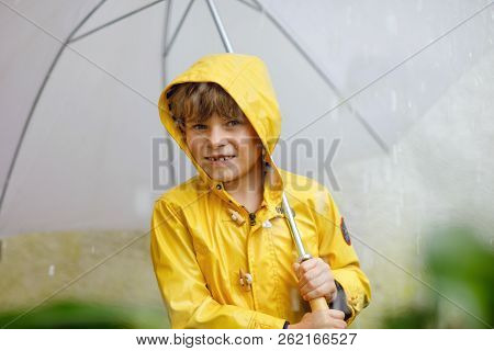 Beautiful Little Kid Boy On Way To School Walking During Sleet, Heavy Rain And Snow With An Umbrella