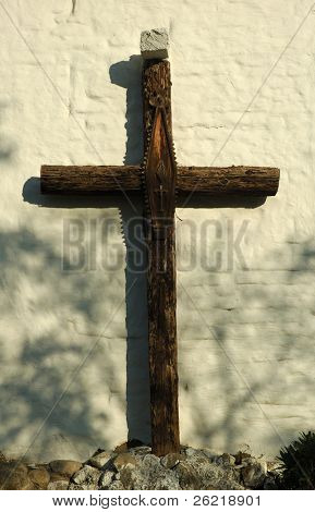 Wooden cross on wall of Mission San Jose in setting sun