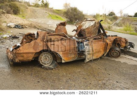 Restos quemados de un coche en un cul de sac