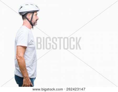 Middle age senior hoary cyclist man wearing bike safety helment isolated background looking to side, relax profile pose with natural face with confident smile.