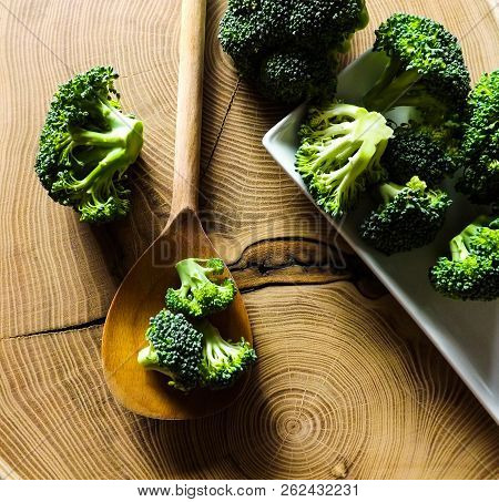 Fresh Broccoli On Wooden Table. Slice Of Wood