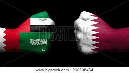 Flags Of Qatar And Its Neighbours Painted On Two Clenched Fists Facing Each Other On Black Backgroun
