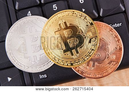 Bitcoins On Compuer Keyboard In Background, Symbol Of Electronic Virtual Money And Mining Cryptocurr
