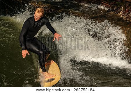 Munich, Germany - Sept 8, 2018: Man Surfing In The Waves Of The Eisbach River In Munich. It Forms A 
