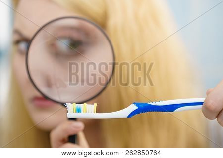 Beautiful Perfectionist Young Woman Checking Her Tooth Brush Through Manifying Loupe Glass. Hygiene,