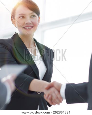 Businesswoman shaking hands with a businssman during a meeting
