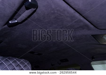 A Close-up View Of A Black Plastic Handle On The Ceiling In A Car In A Passenger Seat Pulled By A Bl