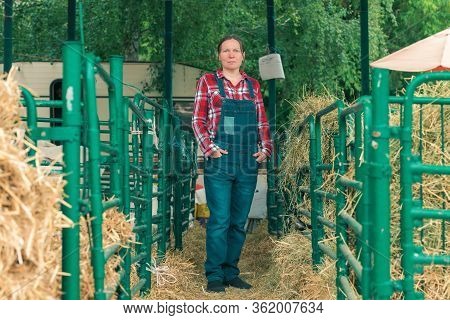Female Farmer Posing On Goat Farm In Front Of The Goatpen
