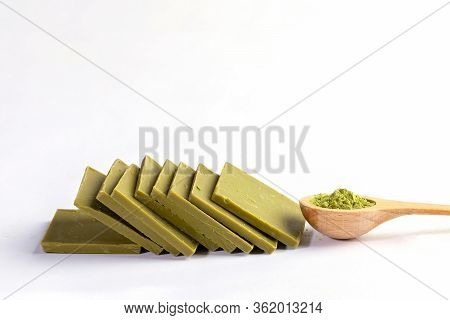 Wooden Spoon Of Japanese Matcha Tea Powder And Slices Of Green Chocolate With Matcha Lying With Domi