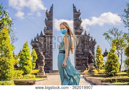 Young Woman Tourist In Medical Mask In Budhist Temple Brahma Vihara Arama Banjar Bali, Indonesia Tou