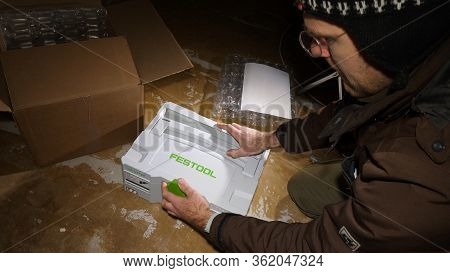 Strasbourg, France - Mar 3, 2020: Overhead View Of Worker Male Unboxing New Systainer From Parcel Co
