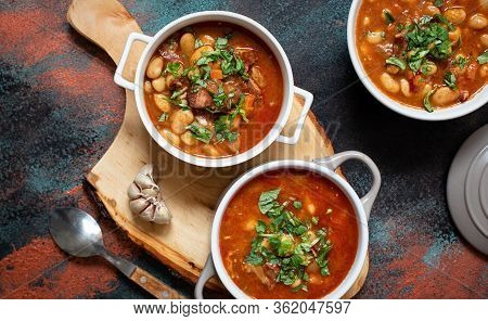 Bean Soup With Meat And Vegetables Served On A Rustic Board With Garlic. Traditional Balkan Soup Or 