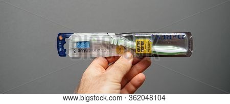 Paris, France - Mar 5, 2020: Close-up Male Hand Holding Dr Best Toothbrush Against Gray Background W