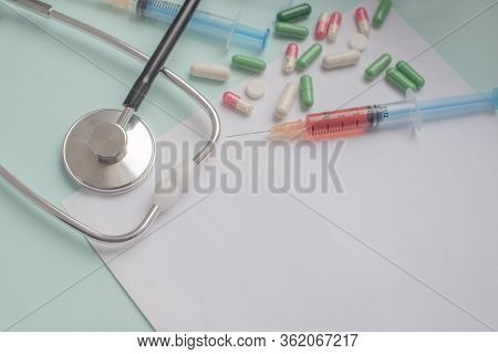 A Syringe With A Blood Test And A Stethophonendoscope With A Patient Questionnaire And Tablets For A