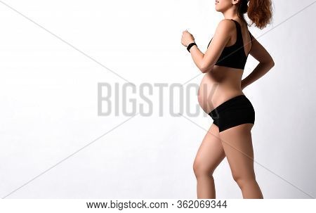 Pregnant Girl With Belly, In Green Sun Visor, Black Sport Shorts And Top, Pink Sneakers. She Is Jogg