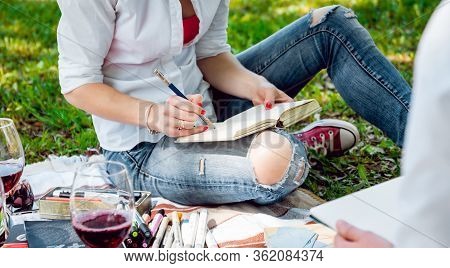 Young Beautiful Girls Drawing The Pictures In Sketchbook.