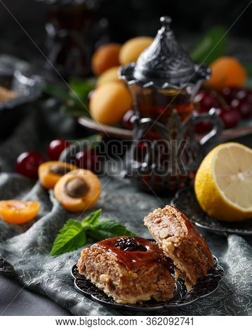 Tea Armud In Turkish Style With Lemon. Served On A Silk Tablecloth With Baklava And Fruit-cherries A