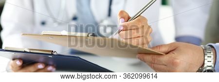 Two Gp Examining Test Results Clipped To Pad Closeu-up