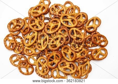 Salty Cracker Cookies In The Shape Of A Pretzel Sprinkled On A White Background. Oktoberfest Symbol 