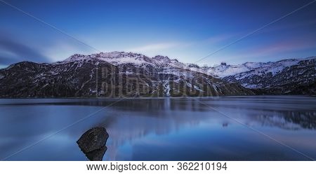 Lake In The French Alps. Reflection Of The Snowy Mountains In Autumn