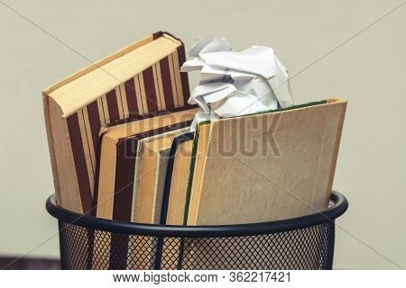 Books And Crumpled Paper In The Bin. Books That Do Not Read, Low-grade Literature_