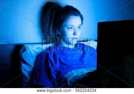 Woman Lying With Her Laptop In Night In The Bedroom In Blue Light At Screen