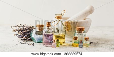 Aromatic Oils In Glass Bottles, Aromatic Salts, Marble Mortar And Dry Lavender. Concept Natural Ogra