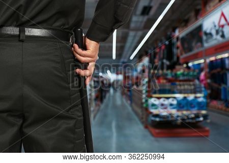 Security Guard In Uniform With Police Baton In Shopping Mall, Closeup. Space For Text