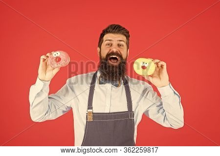 At Baker Shop. Mature Man Red Backdrop. Skilled Baker With Donut Dessert. Funny Hipster Cook Doughnu