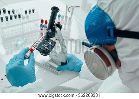 COVID-19. Doctor, microbiologist, scientist in a protective suit, makes a study of coronavirus in the laboratory. Coronavirus test.