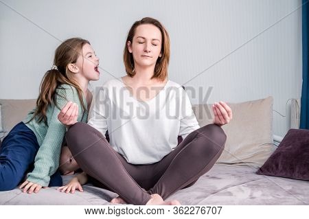 Calm Mindful Single Mom Doing Yoga At Home While Active Noisy Kid Daughter Screaming In Her Ear, Mot
