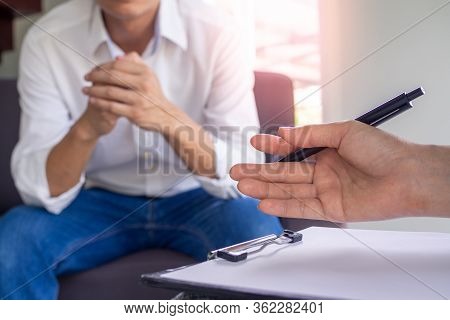 The Image Focuses On The Psychiatrist's Hand. The Clipboard Records The Illness. Is Healing The Mind