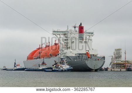 Lng Terminal And Gas Tanker - A Large Ship Maneuvers Into The Unloading Quay