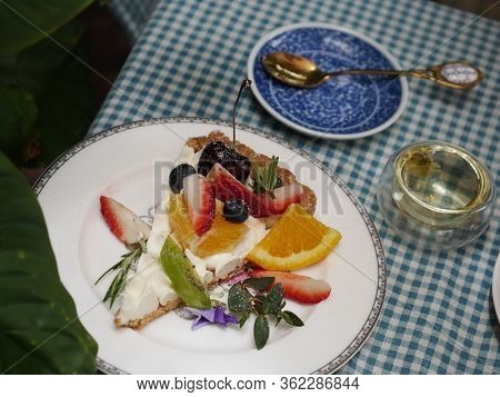 Beautiful Cheesecake With Fresh Fruits - Gold Spoon And Floweer Tea Background On Polka Dot Tableclo
