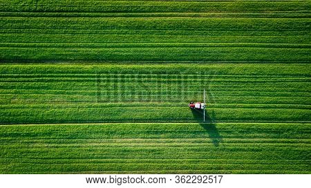 Straight Lines Field With A Tractor Spreading