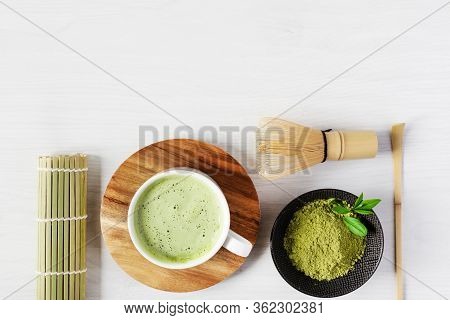 Green Matcha Tea Latte And Tea Accessories On White Wooden Background Top View. Japanese Tea Ceremon