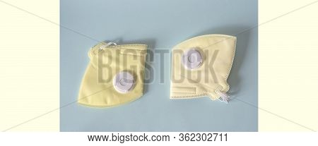 Two Yellow Masks With A Respirator On A Blue Background. Space For Copying. Pandemic, Protection Fro