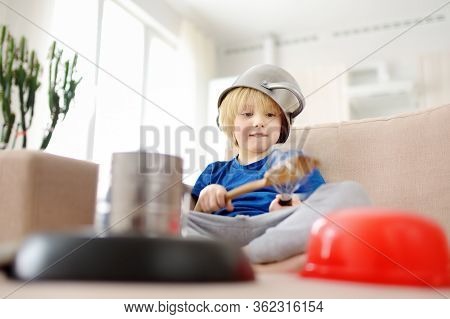 Mischievous Preschooler Boy Play The Music Using Kitchen Tools And Utensils At Home During Quarantin