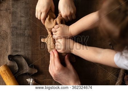 Children Play With Salt Dough On The Kitchen Table. Hands Mold Clay With Their Own Hands To Create H