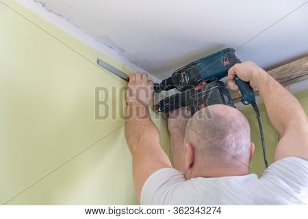 Fastening To The Wall Guide For Stretch Ceiling. Repairers Make Installation Of A Stretch Ceiling