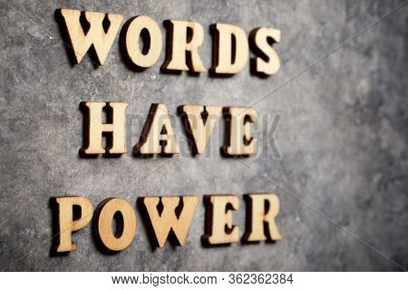 Words have power text on a gray paper.