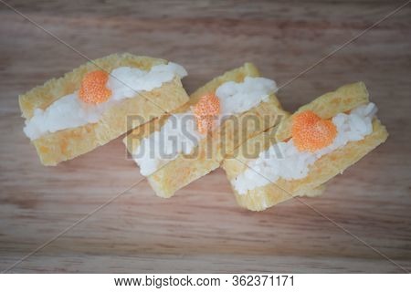 Grilled Tamago Sushi With Rice And Ebiko On Wood Tray