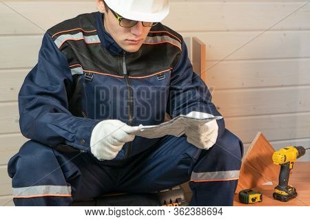 The Professional Collector Of Furniture Reading The Instructions To Assemble Furniture. Assembly Of 