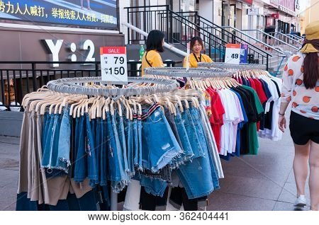 China, Heihe, July 2019: Selling Clothes On The Street. Street Of The Chinese City Of Heihe In Summe