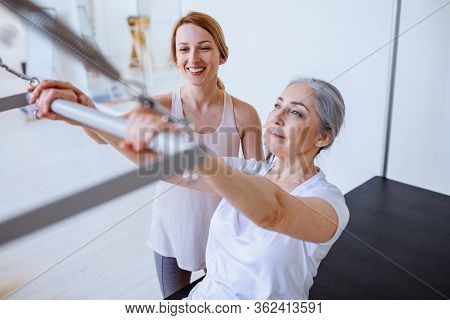 Pilates Aerobic Female Instructor Workout With Fit Man In Cadillac Fitness Exercise. Active And Heal