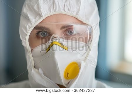 Woman In White Workwear And Protective Eyeglasses Looking Determined