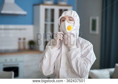 Woman In White Workwear Wearing A Respirator
