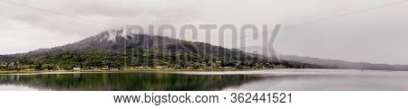 Lake Buyan Against Background Of Mountain Rainforest And Clouds